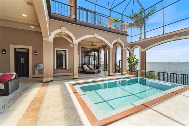 a living room with furniture a fireplace and floor to ceiling windows