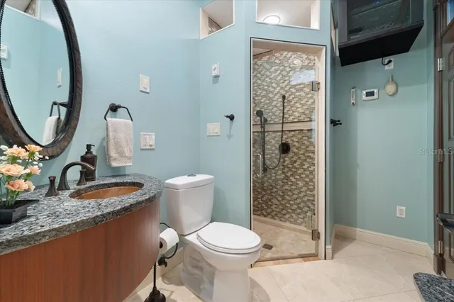 a bathroom with a granite countertop sink toilet and shower