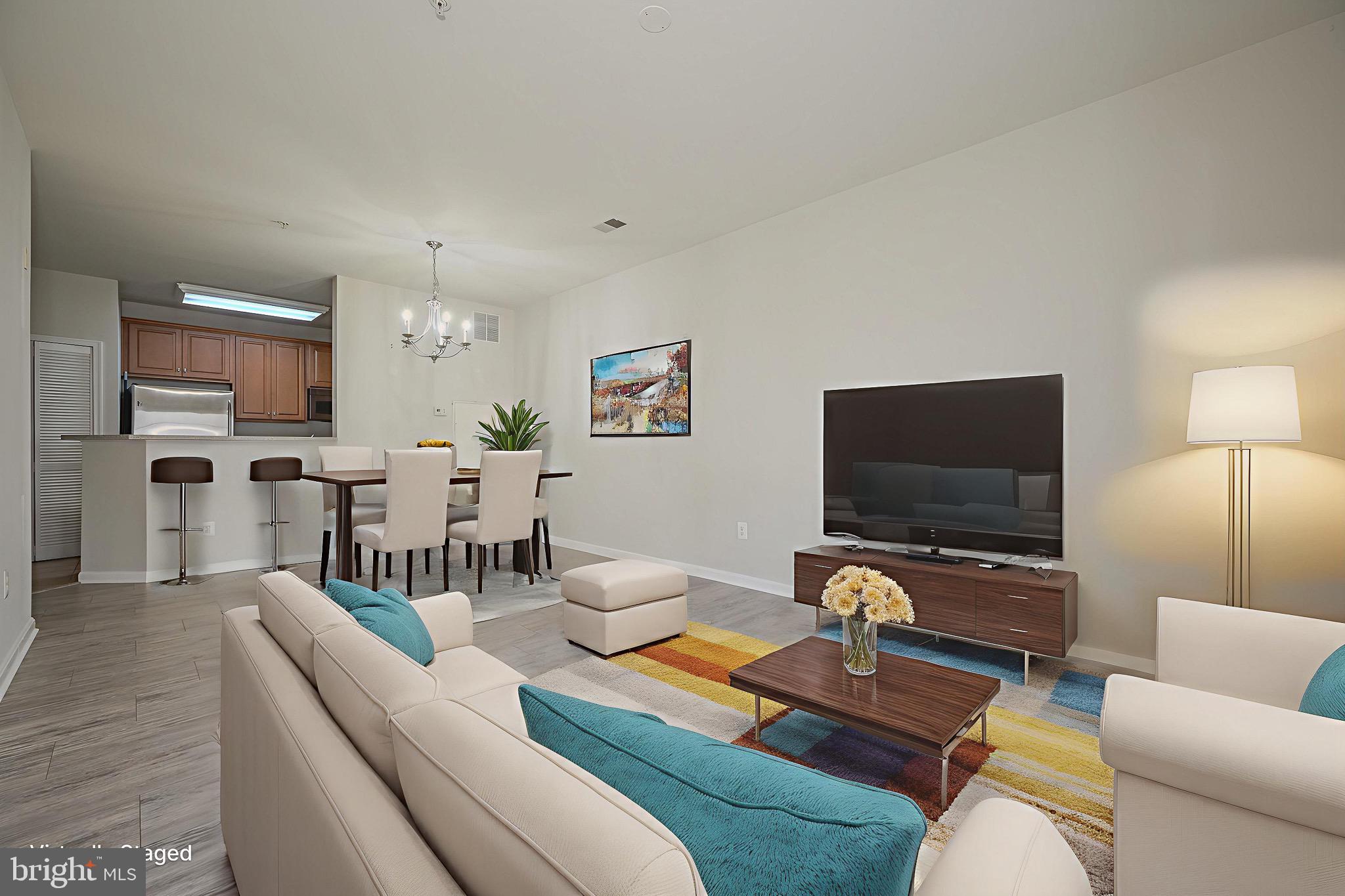 21216 McFadden Square, Unit 206 Sterling, VA 20165 - Photo 4 of 11 a living room with furniture and a flat screen tv