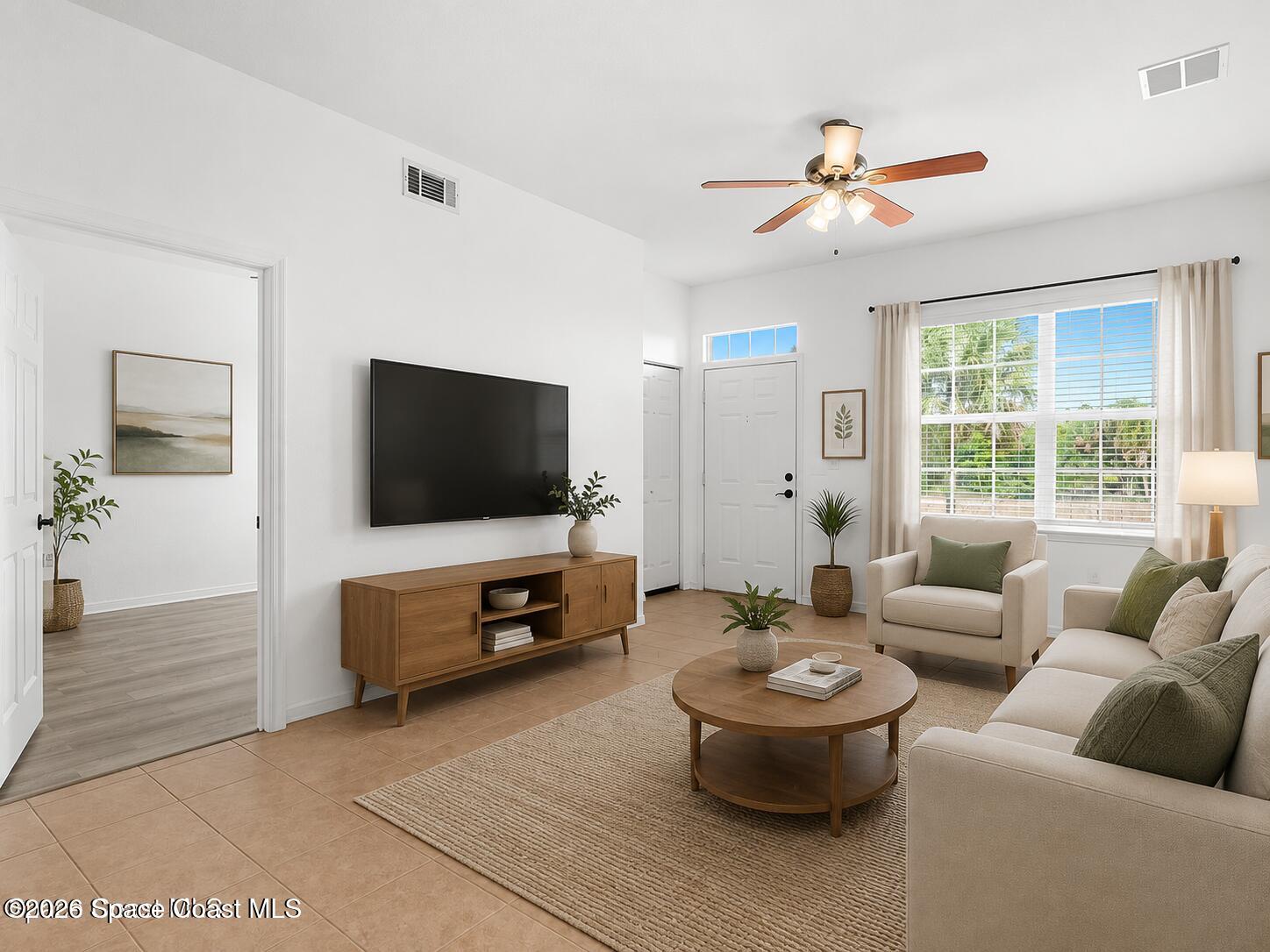 110 Turpial Way, Unit 106 Melbourne, FL 32901 - Photo 10 of 50 a living room with furniture and a flat screen tv