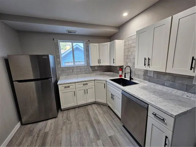 a kitchen with a refrigerator sink and cabinets