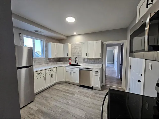 a kitchen with a refrigerator sink and cabinets