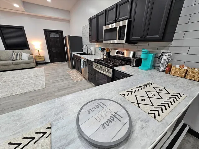 a view of a kitchen with fridge and wooden floor
