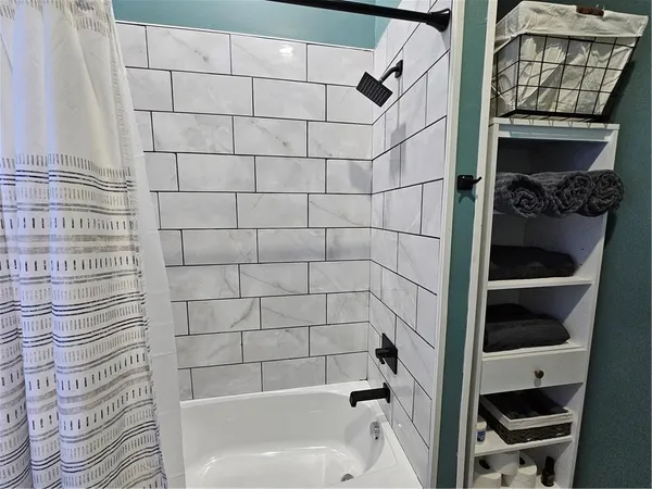 a bathroom with a bathtub and a shower