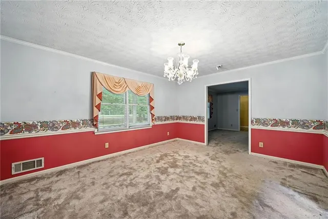 a view of a livingroom with a chandelier fan and windows