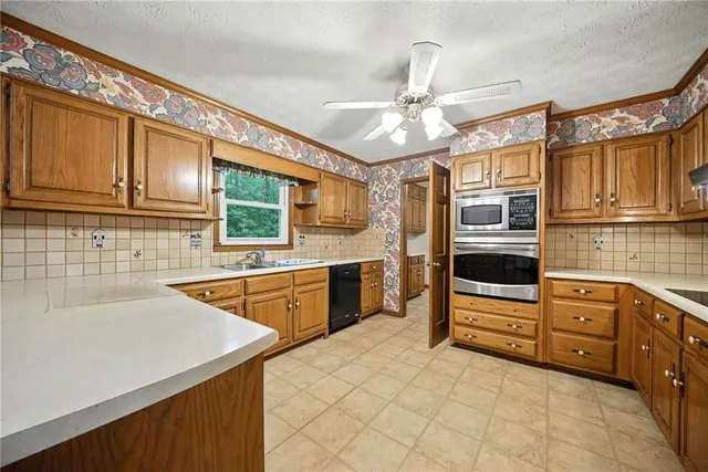 a kitchen with stainless steel appliances granite countertop a sink and cabinets