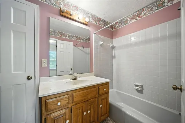 a bathroom with a shower sink vanity and mirror
