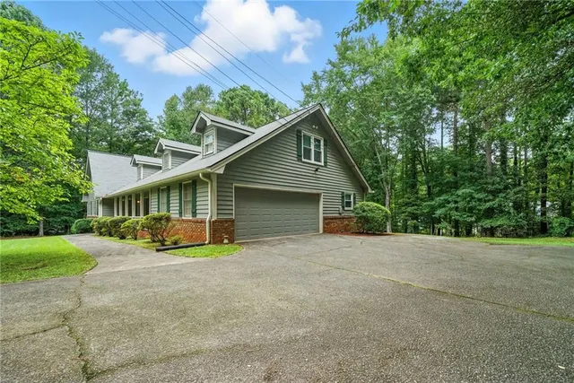 a view of a house with a yard and large trees