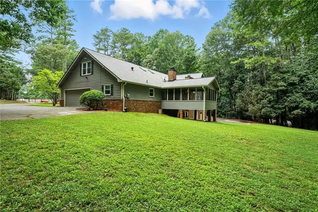 a view of a house with a yard and sitting area