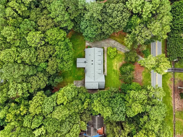 an aerial view of a house with a yard and large trees