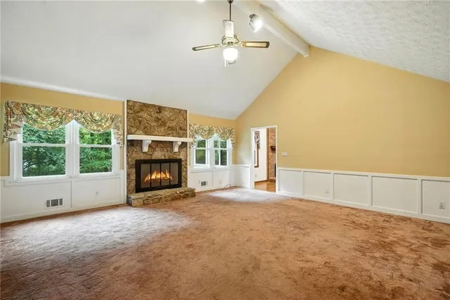 a view of an empty room with a fireplace and a window