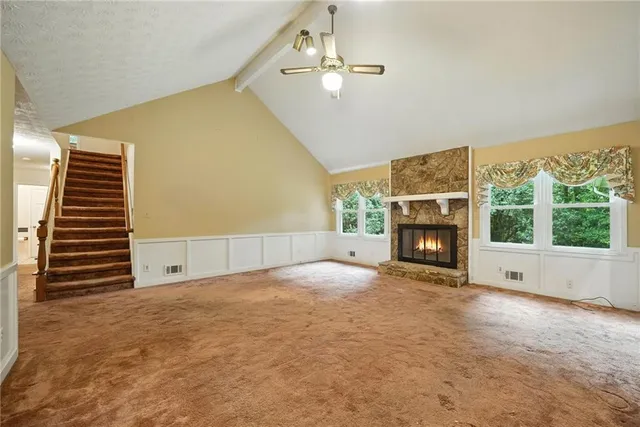 a view of empty room with fireplace and fan