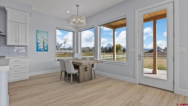 a dining room with furniture a chandelier and wooden floor