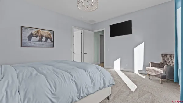 a spacious bedroom with a bed a couch and a flat screen tv