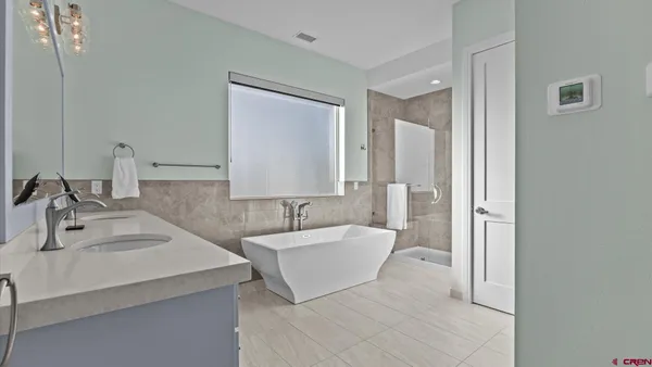 a bathroom with a double vanity sink mirror and bathtub