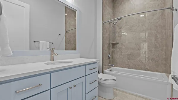 a bathroom with a granite countertop sink a toilet and shower