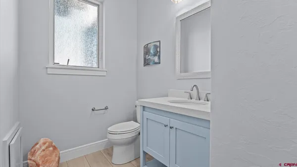 a bathroom with a toilet a sink a vanity and mirror
