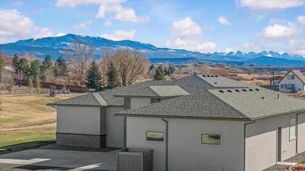 a aerial view of a house with a yard and mountain view