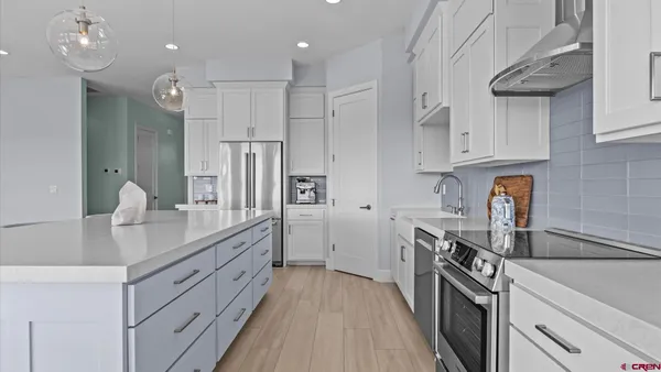 a kitchen with white cabinets and stainless steel appliances