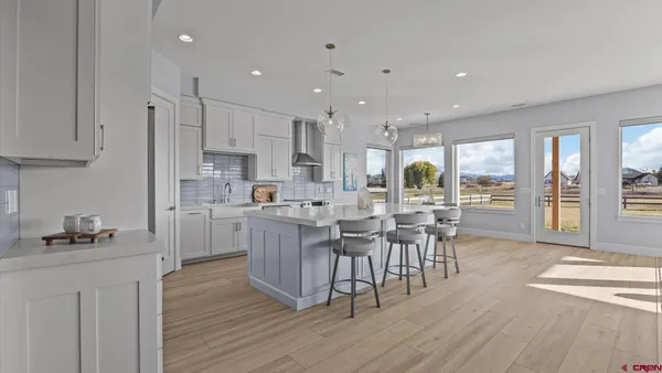 a kitchen with kitchen island granite countertop a sink cabinets and wooden floor