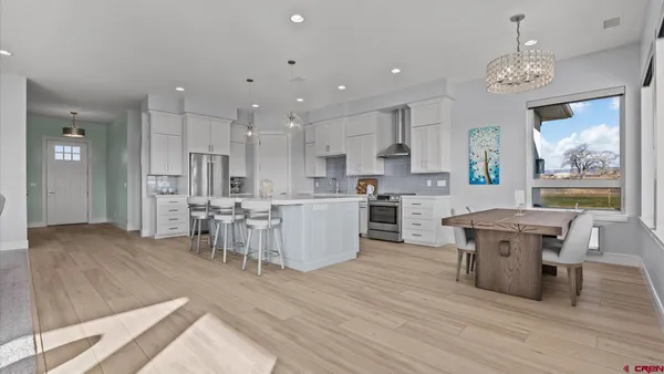 a large kitchen with cabinets wooden floor and stainless steel appliances