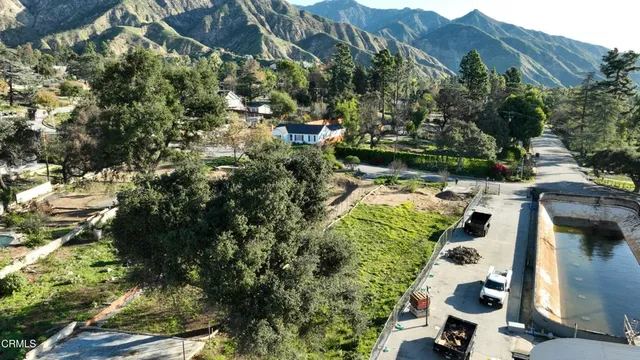 an aerial view of residential houses with outdoor space and trees