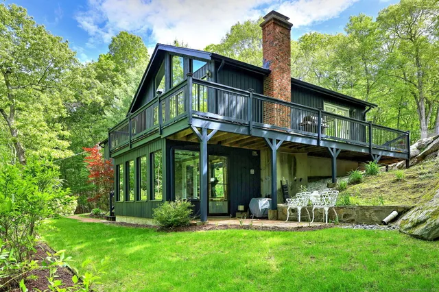 a view of house with a yard and sitting area