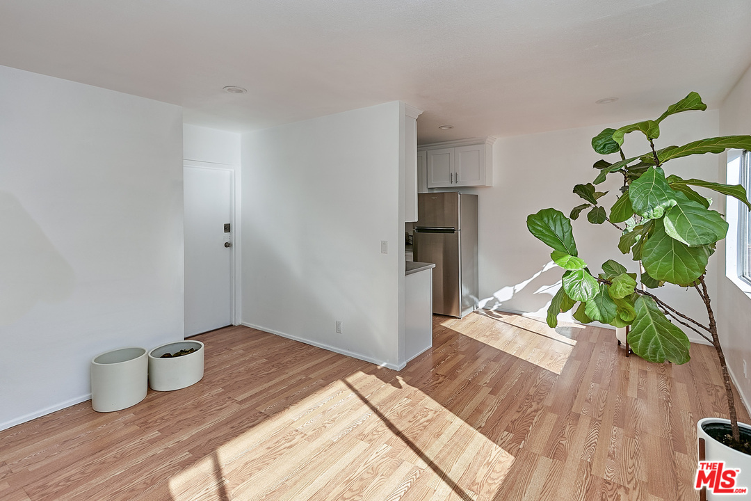 433 Cottage Home Street, Unit 4 Los Angeles, CA 90012 - Photo 2 of 13 a bedroom with a bed and a wooden floor