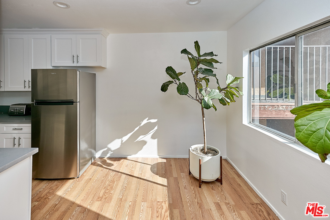 433 Cottage Home Street, Unit 4 Los Angeles, CA 90012 - Photo 4 of 13 a vase of flowers sitting on a table with kitchen view