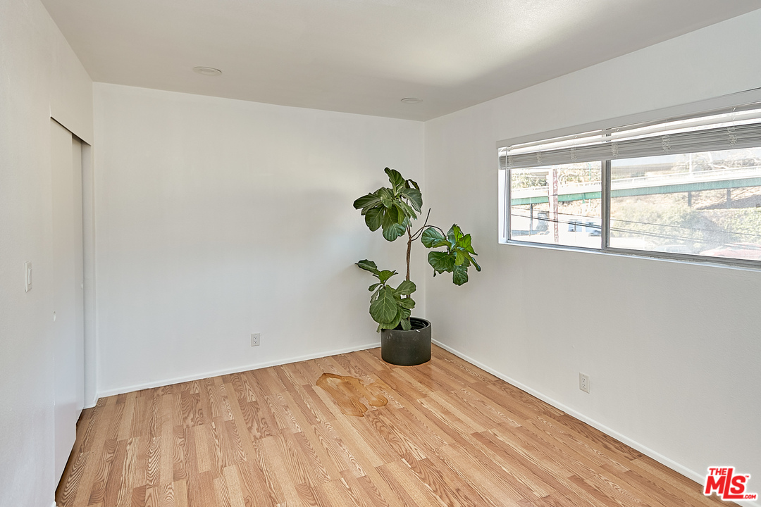 433 Cottage Home Street, Unit 4 Los Angeles, CA 90012 - Photo 6 of 13 a view of a room with wooden floor and a potted plant