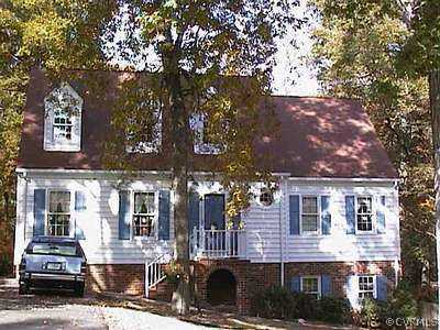 a front view of a building with large trees
