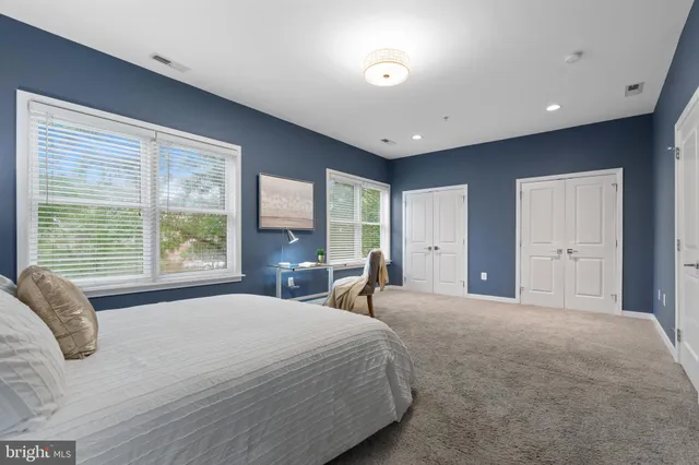 a spacious bedroom with a large bed and windows