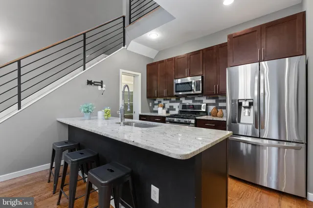 a kitchen with kitchen island a counter space a sink appliances and cabinets