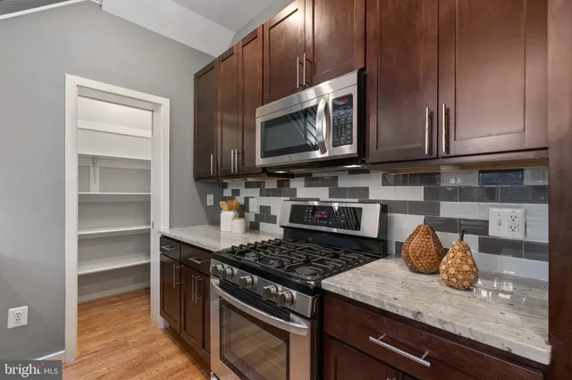 a kitchen with stainless steel appliances granite countertop a stove and a microwave