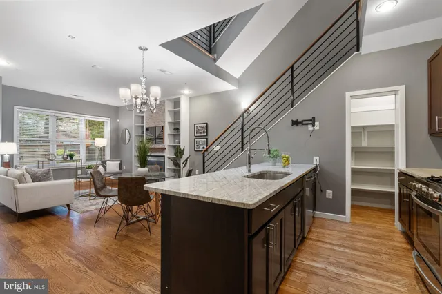 a kitchen with a stove a refrigerator a dining table and chairs with wooden floor