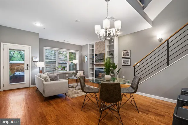 a view of a livingroom with furniture a chandelier and wooden floor