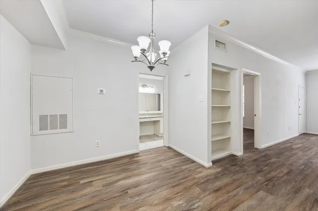 a view of a room with wooden floor and a ceiling fan