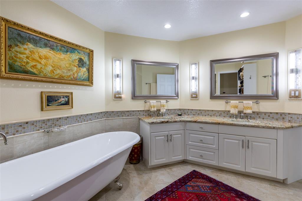 9341 Blind Pass Road St. Pete Beach, FL 33706 - Photo 21 of 44 a spacious bathroom with a granite countertop tub sink and mirror
