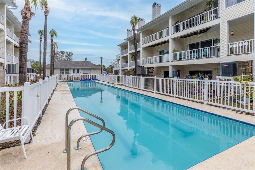 9341 Blind Pass Road St. Pete Beach, FL 33706 - Photo 26 of 44 a view of a swimming pool with a balcony