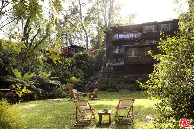 a view of a house with a yard and trees