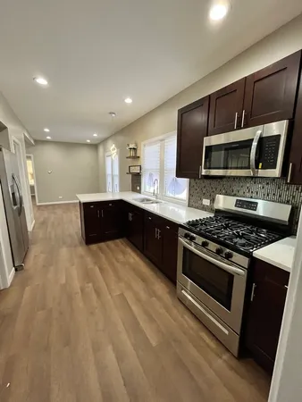a kitchen with stainless steel appliances kitchen island granite countertop a stove and a sink