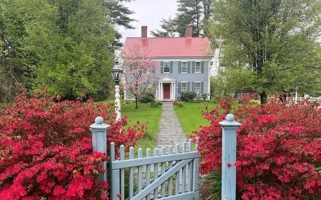 a front view of a house with a yard and fountain