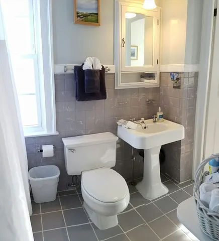 a bathroom with a sink toilet and mirror