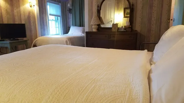 a bedroom with a bed and a flat tv screen on dresser