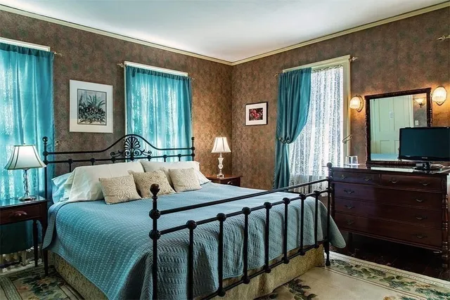 a bedroom with a bed and a flat tv screen