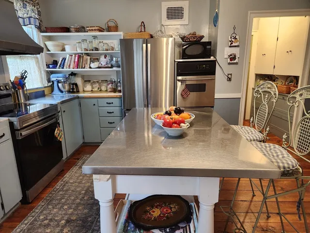 a kitchen with stainless steel appliances a stove a refrigerator and cabinets