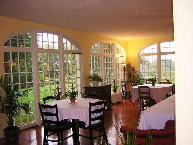 a dining room with furniture large windows and wooden floor