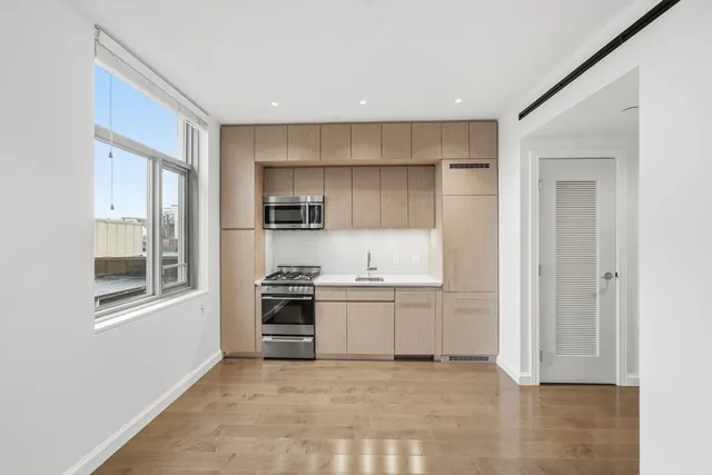 a view of a kitchen with a sink stove and cabinet