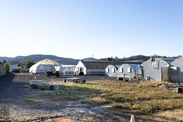 a view of a big house with a big yard and large trees