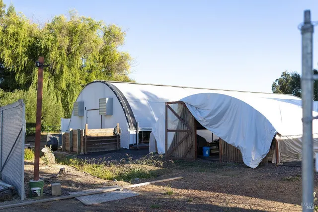 a front view of a house with a garden and lake view